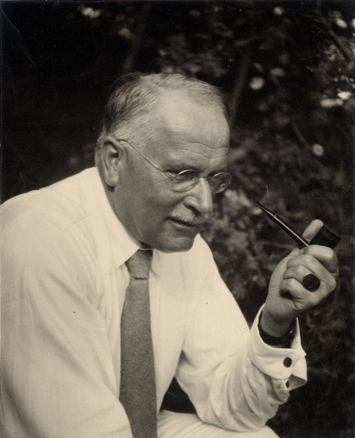 Carl Gustav Jung z fajka w dloni, w bialej koszuli i krawacie - fotografia w sepii