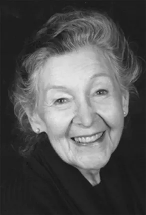 Marion Woodman - usmiechnieta starsza kobieta na ciemnym tle, czarno-biala fotografia