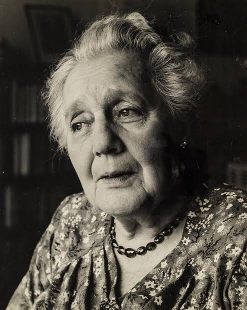 Melanie Klein w starszym wieku - archiwalny portret w kwiecistej sukni na tle regalu z ksiazkami