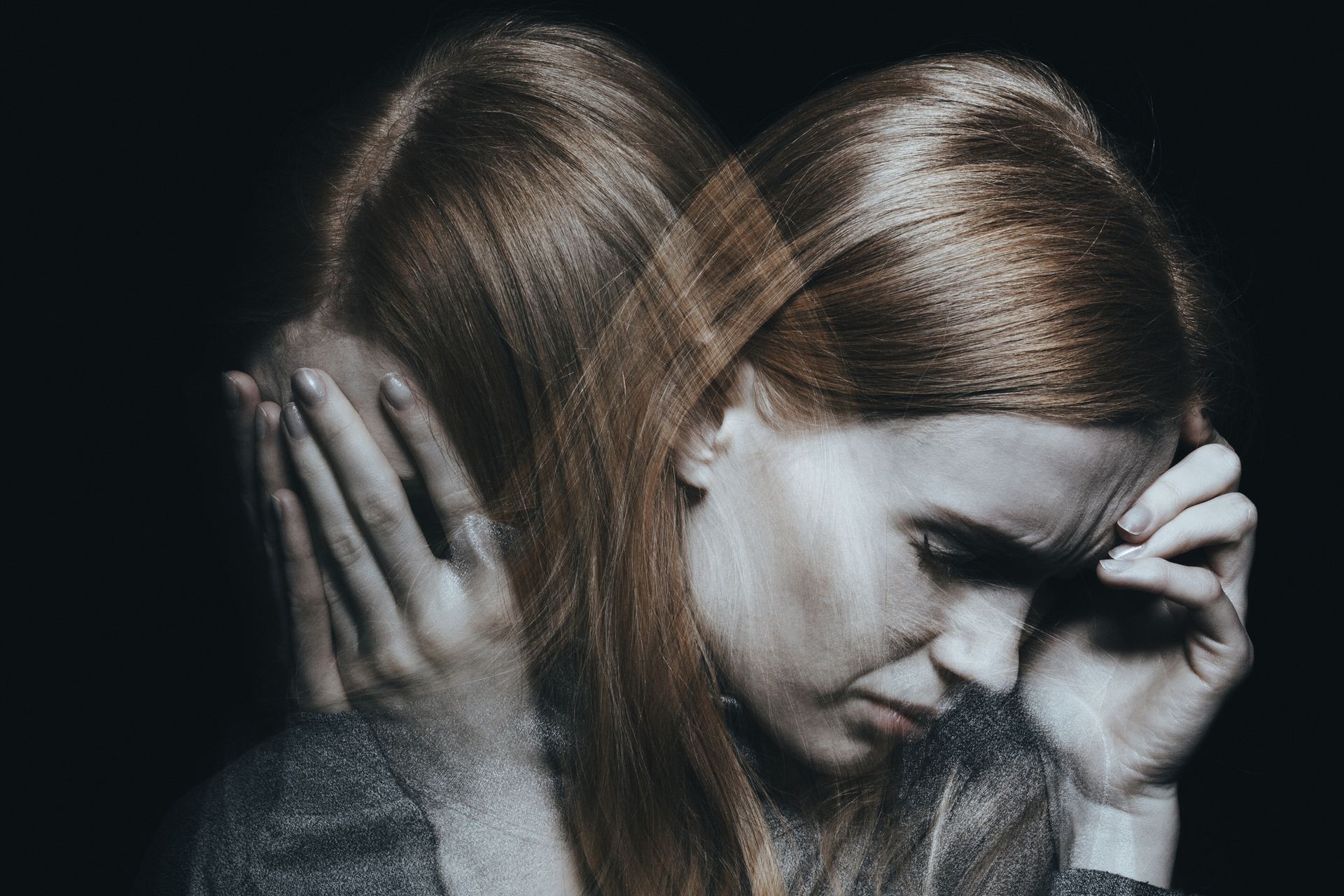 Kobieta z podwójną ekspozycją – rozmyta sylwetka symbolizująca wewnętrzną niestabilność i fragmentację tożsamości